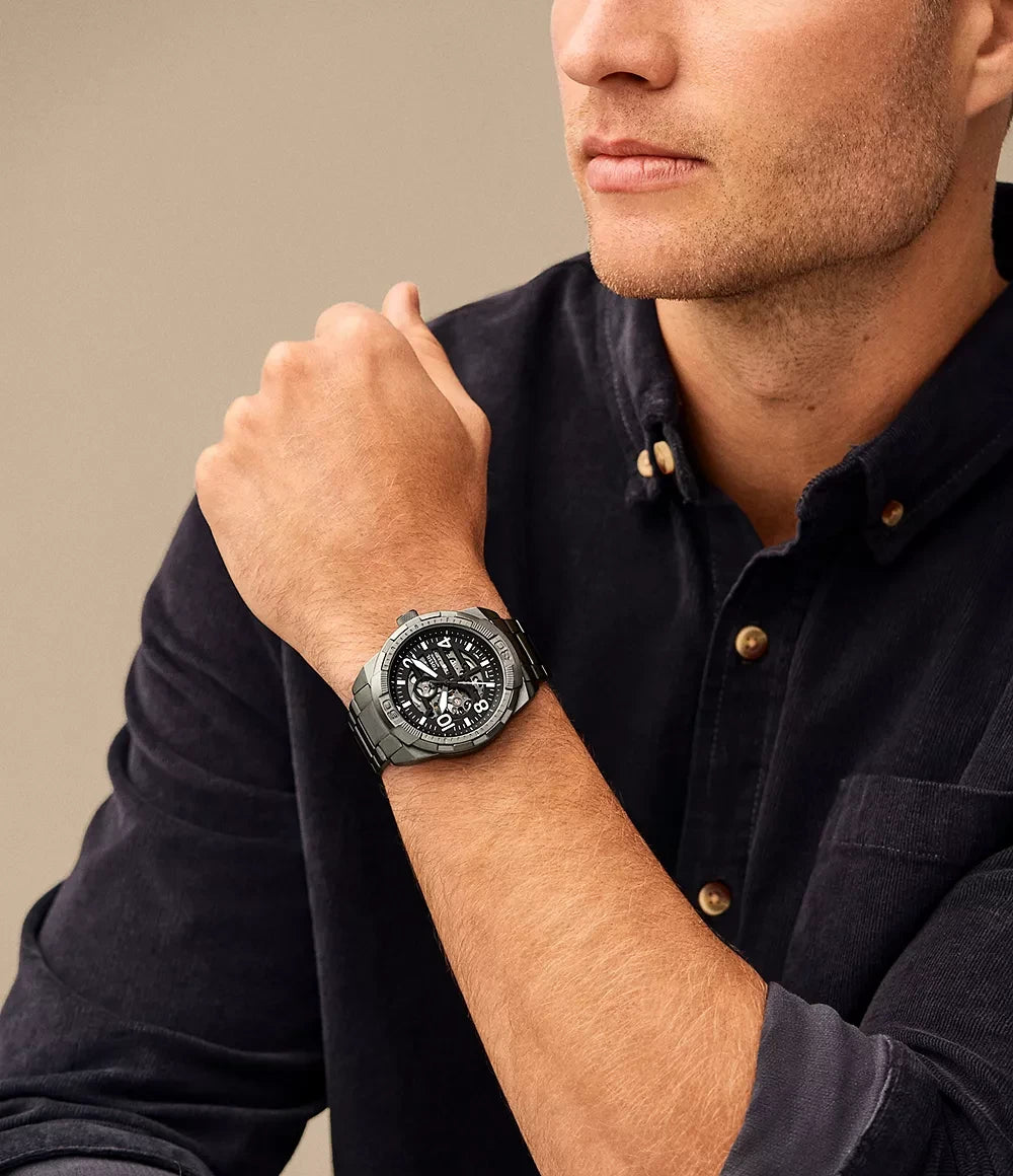 Fossil ME3255 worn on wrist – black satin dial and smoke stainless steel bracelet offering a versatile and stylish look – sophisticated men’s watch presented by HEY WATCH.