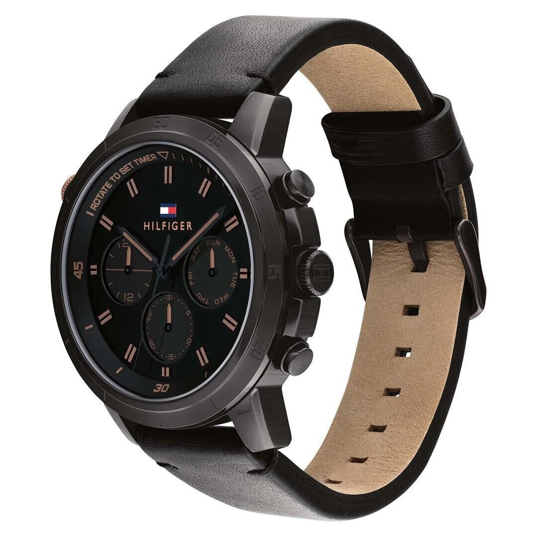 Tommy Hilfiger 1792110 angled view – sleek black stainless steel case with black dial and leather strap – men’s watch by HEY WATCH.