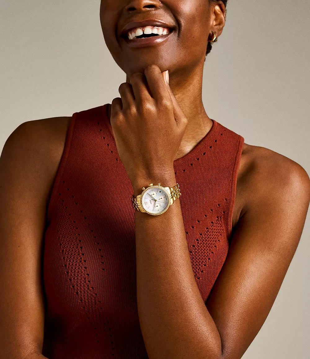 Fossil ES5358 worn on wrist – white mother-of-pearl dial and gold-tone bracelet offering a versatile and stylish look – sophisticated women’s watch presented by HEY WATCH.