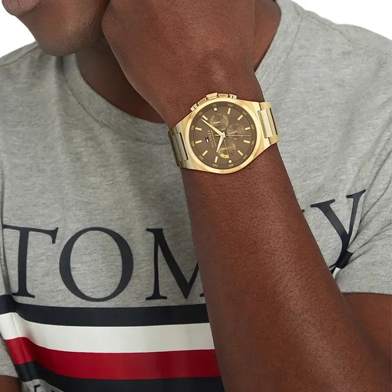 Tommy Hilfiger 1792090 on wrist – men’s gold stainless steel chronograph watch with brown dial worn in lifestyle setting – Dexter collection by HEY WATCH.